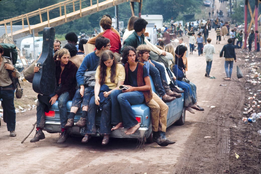 A group of hippies catch a ride to Woodstock in 1969.