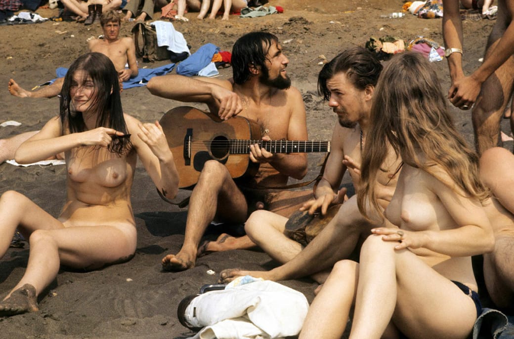 A group of naked hippies lounge on the beach during the Isle of Wight Festival in 1969.