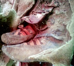 Archaeologists in Mongolia are slowly unwrapping the mummy of a suspected ancient woman found preserved in the Altai Mountains. So far only one hand and her feet in modern-looking boots (pictured) are visible, but experts believe the find dates to around 1,500 years ago