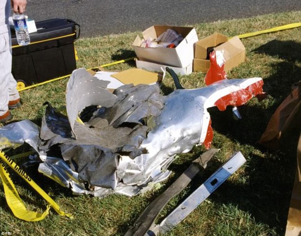 Forensics officers cordoned off the area around where part of what appears to be the plane's fuselage in American Airlines colors was left on the lawn outside the Pentagon