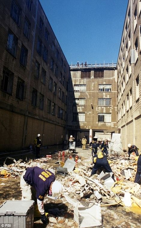 Pictured above  is members of the FBI and firefighters removing the carnage of the Pentagon after the attack